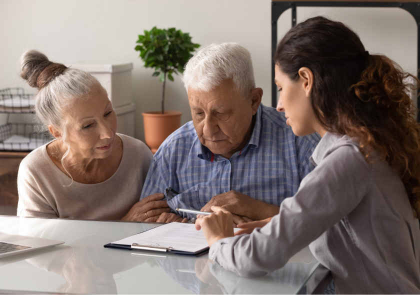 A woman explaining a contract to two older adults