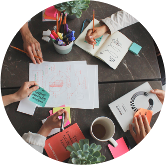 Group of people sitting around a table with papers and pens