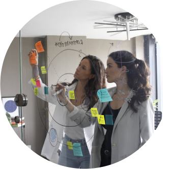 Alejandra and Regina writing on a glass board